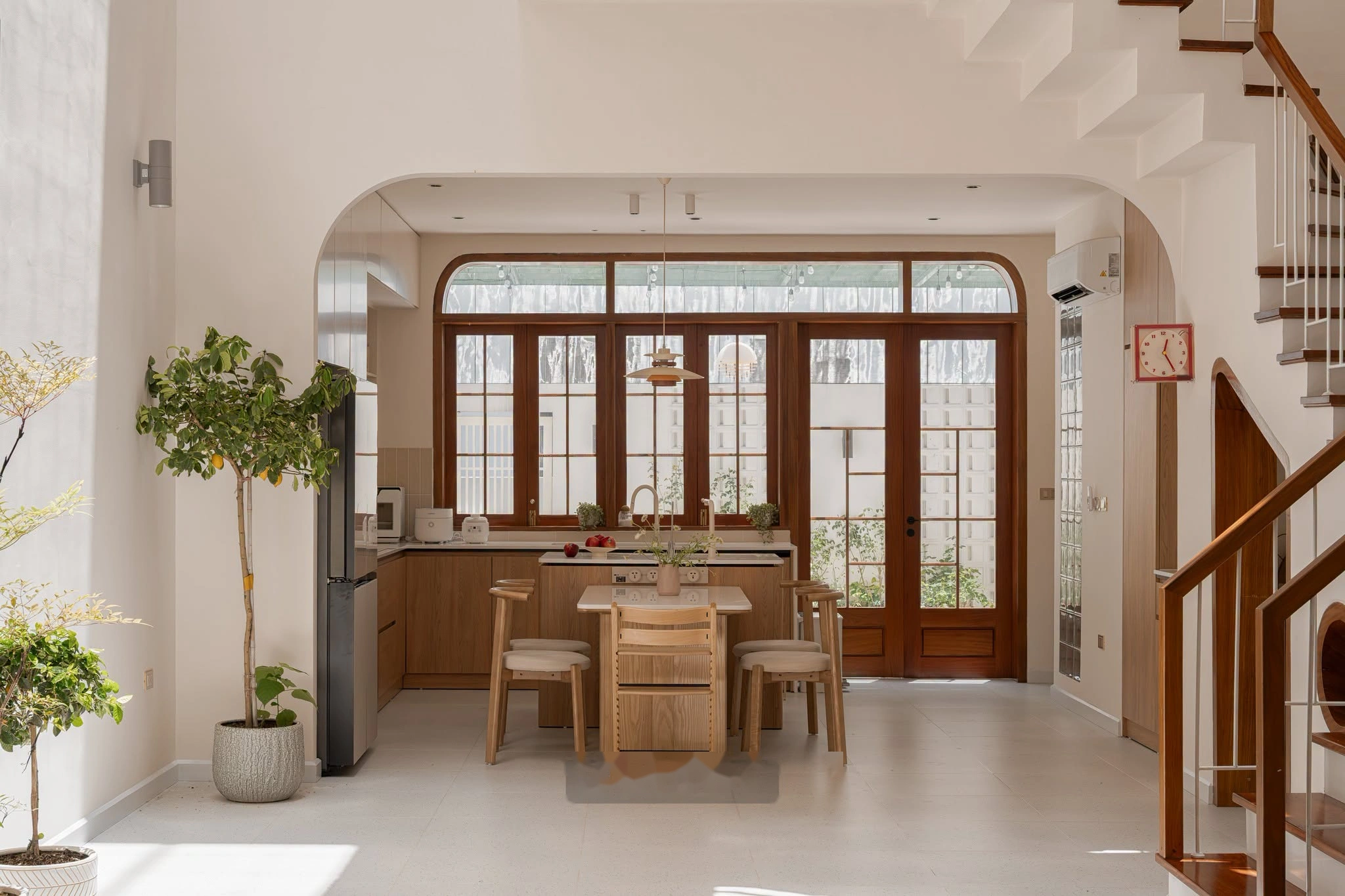 Không gian bếp và bàn ăn gỗ sồi ấm cúng view sân sau thông thoáng